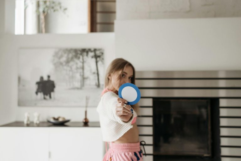 A woman poses indoors holding a round blue cutout symbolizing diabetes awareness.