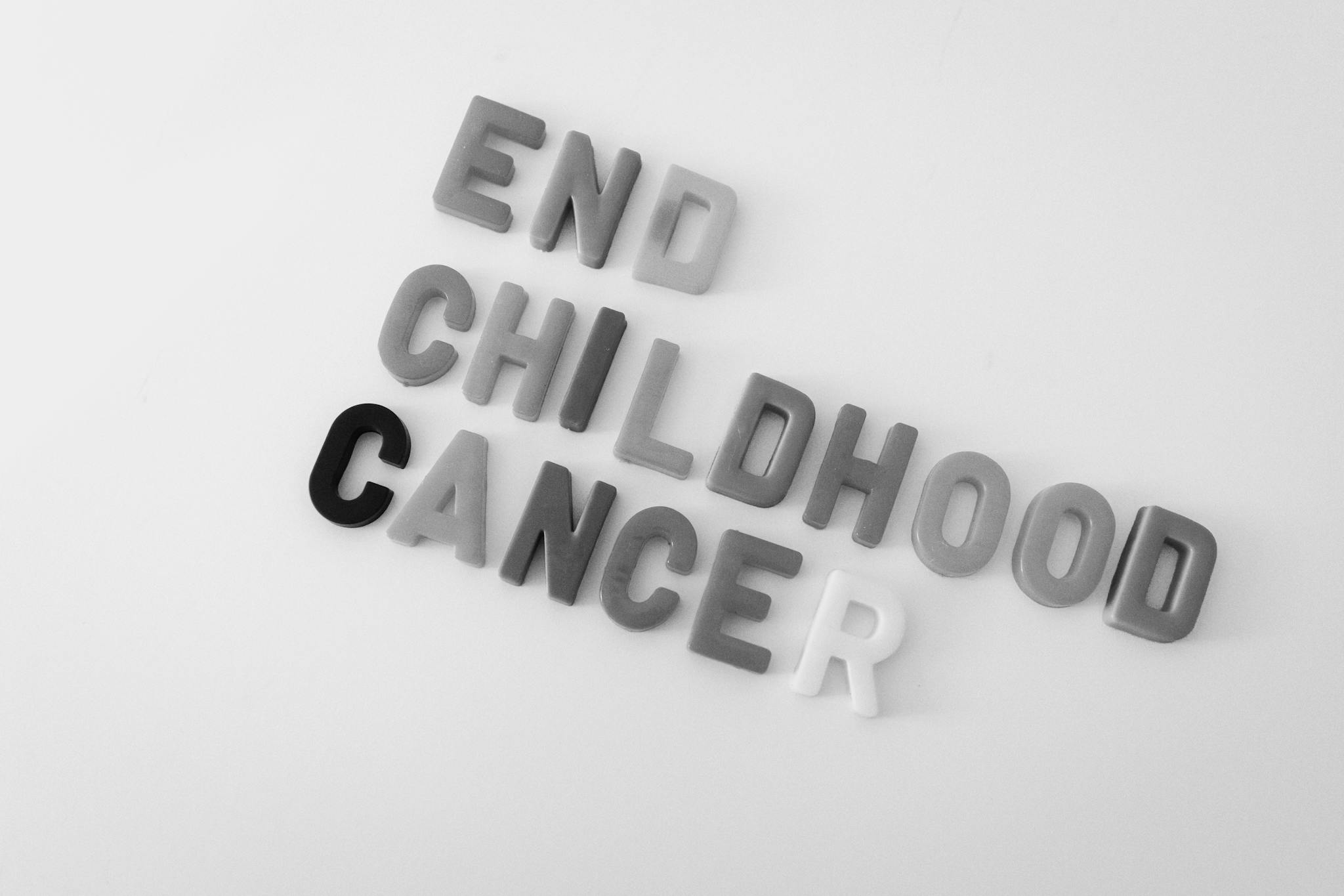 Black and white image promoting end of childhood cancer using bold letters.